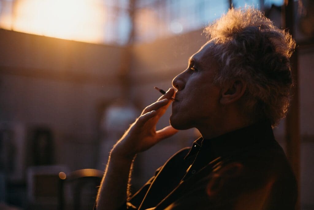 Pessoa fumando cigarro comum.